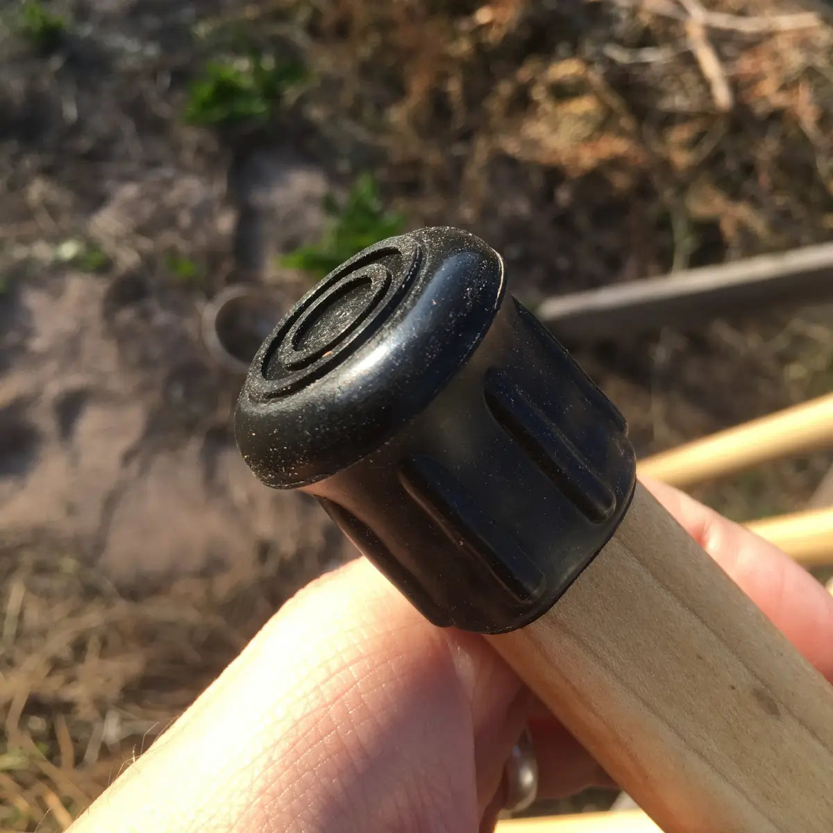 Close up of ridged made in usa rubber walking stick tip fastened to bottom of poplar hardwood shaft