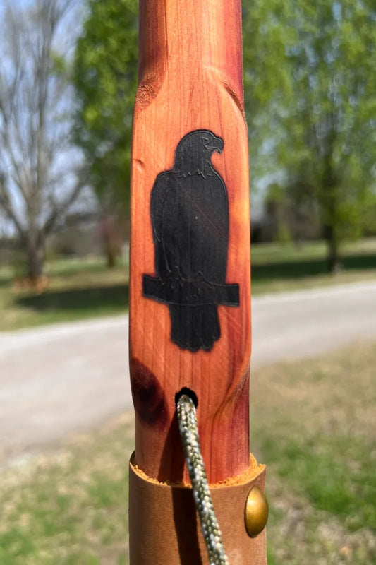 Handcrafted red cedar wood walking stick with engraved perched bald eagle sitting on a branch, paracord, and leather grip, made in USA