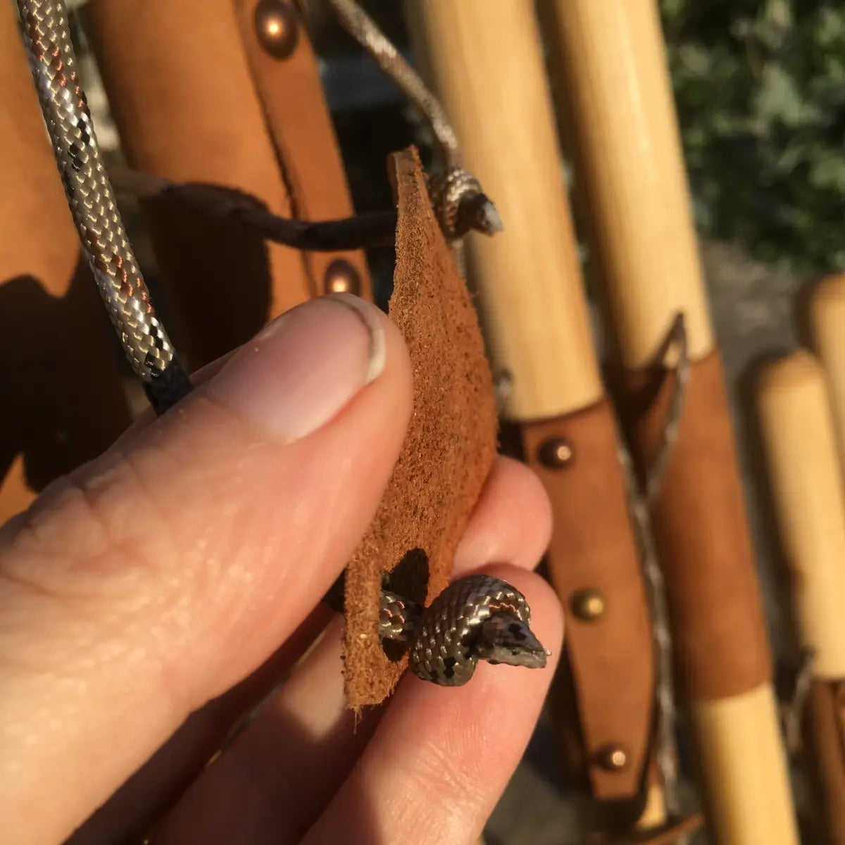 leather branded wrist cradle, back with paracord strap  fastened to it
