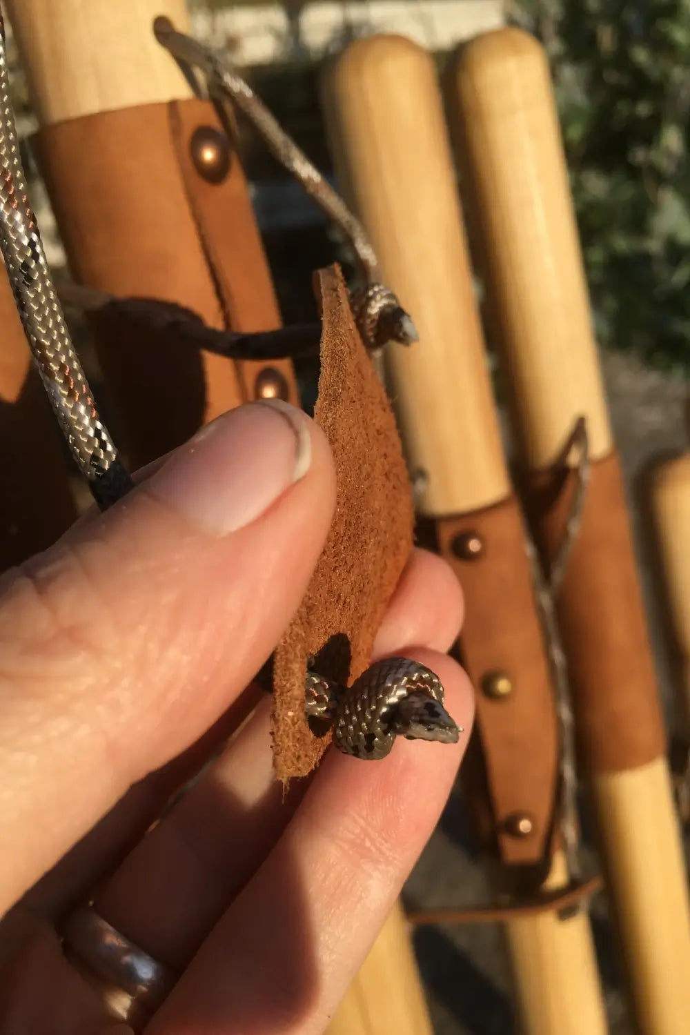leather branded wrist cradle, back with paracord strap  fastened to it