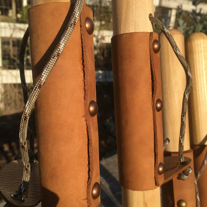Full-grain leather grip with antique brass rivets and paracord wrist strap on handcrafted poplar walking stick