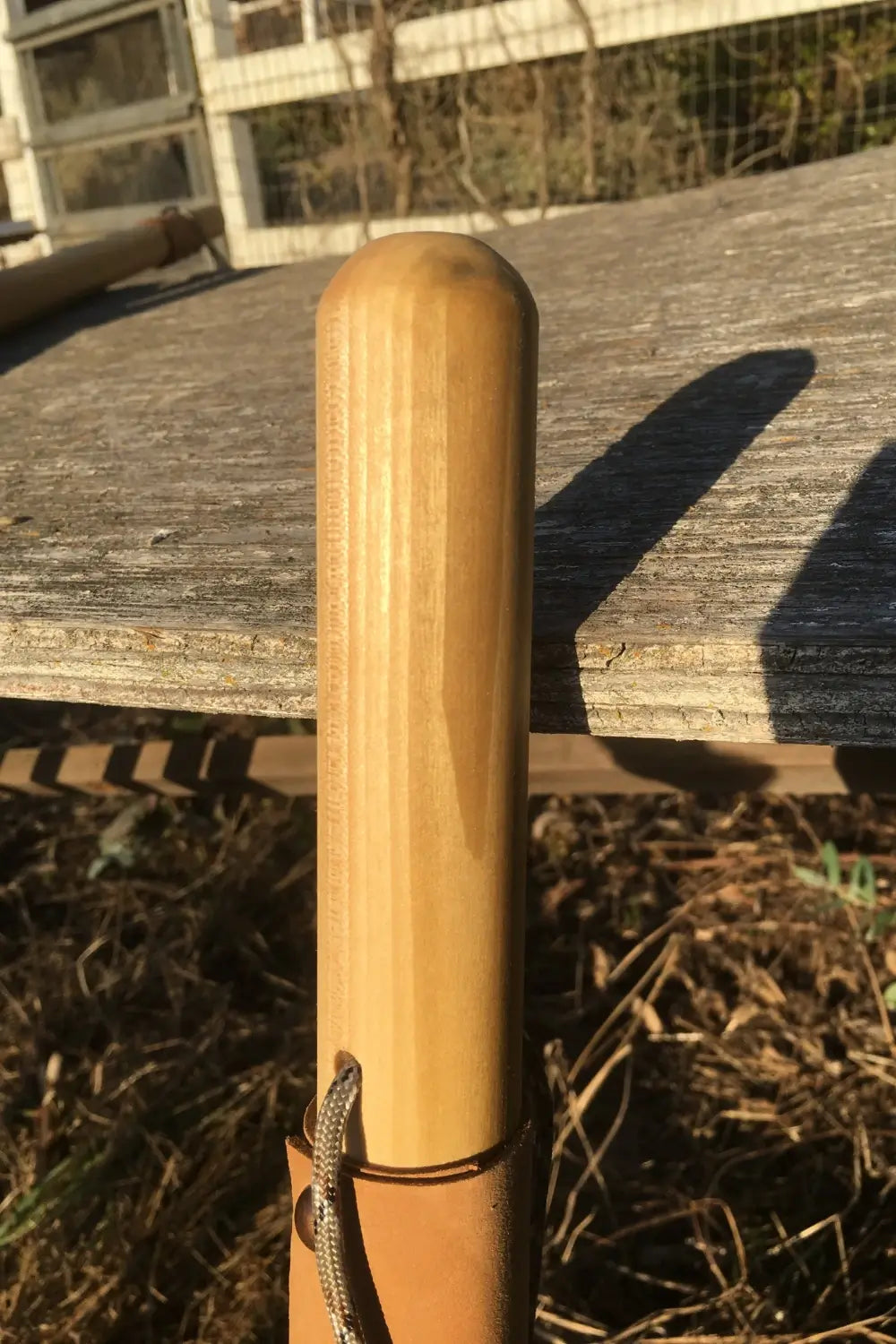 poplar hardwood upper staff shaft with rounded over top and paracord strap peeking up from bottom