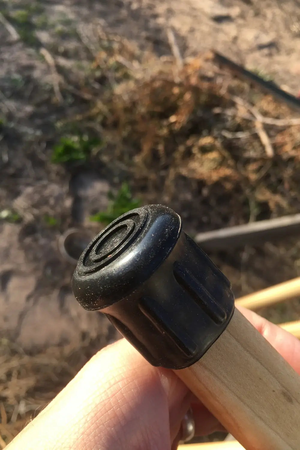 Close up of ridged made in usa rubber walking stick tip fastened to bottom of poplar hardwood shaft