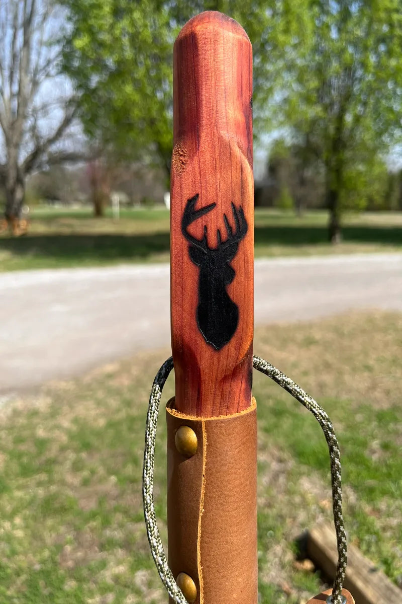 Handcrafted red cedar wood walking stick with engraved deer, paracord, and leather grip with brass buttons, made in USA