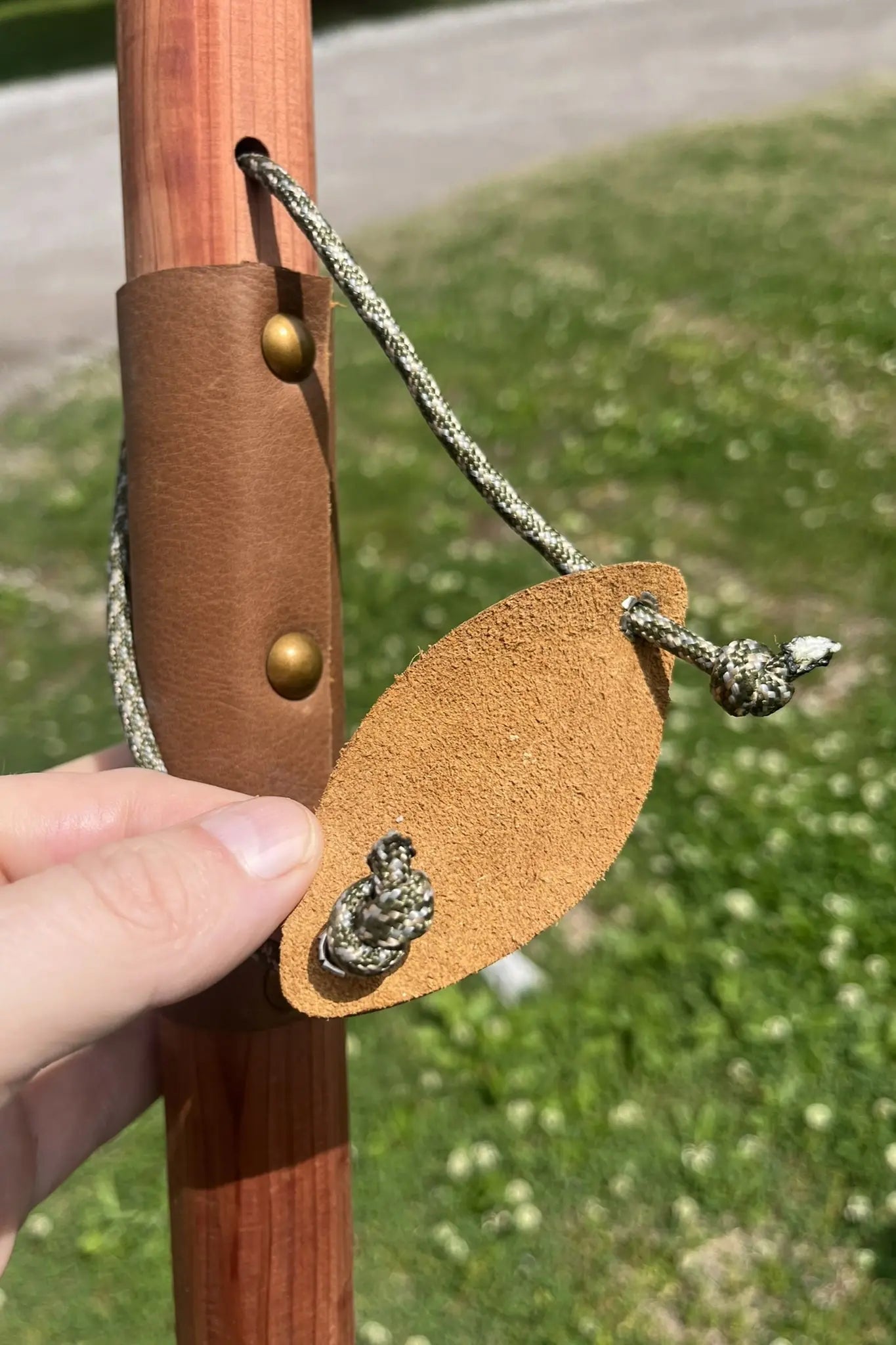Back of soft leather wrist cradle showing simple adjustable paracord knots on handcrafted red cedar wood walking stick, made in USA