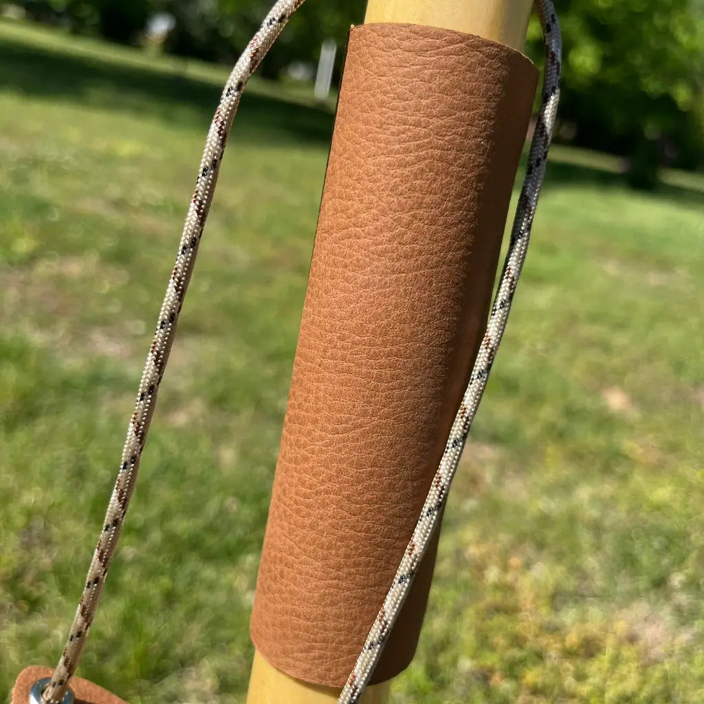 Leather wrist strap detail — pebble grain grip exterior, paracord loop