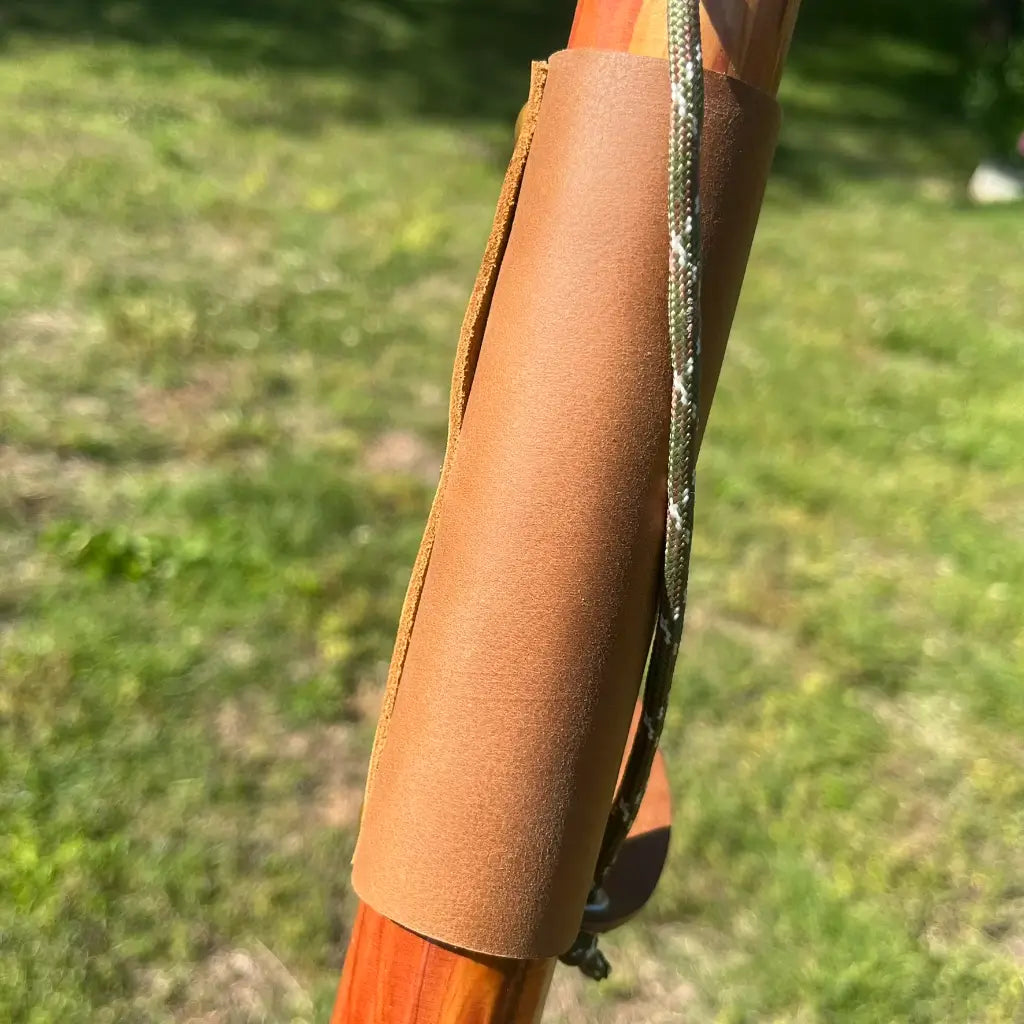 Leather grip wrap on red cedar walking cane shaft with camo paracord wrist strap
